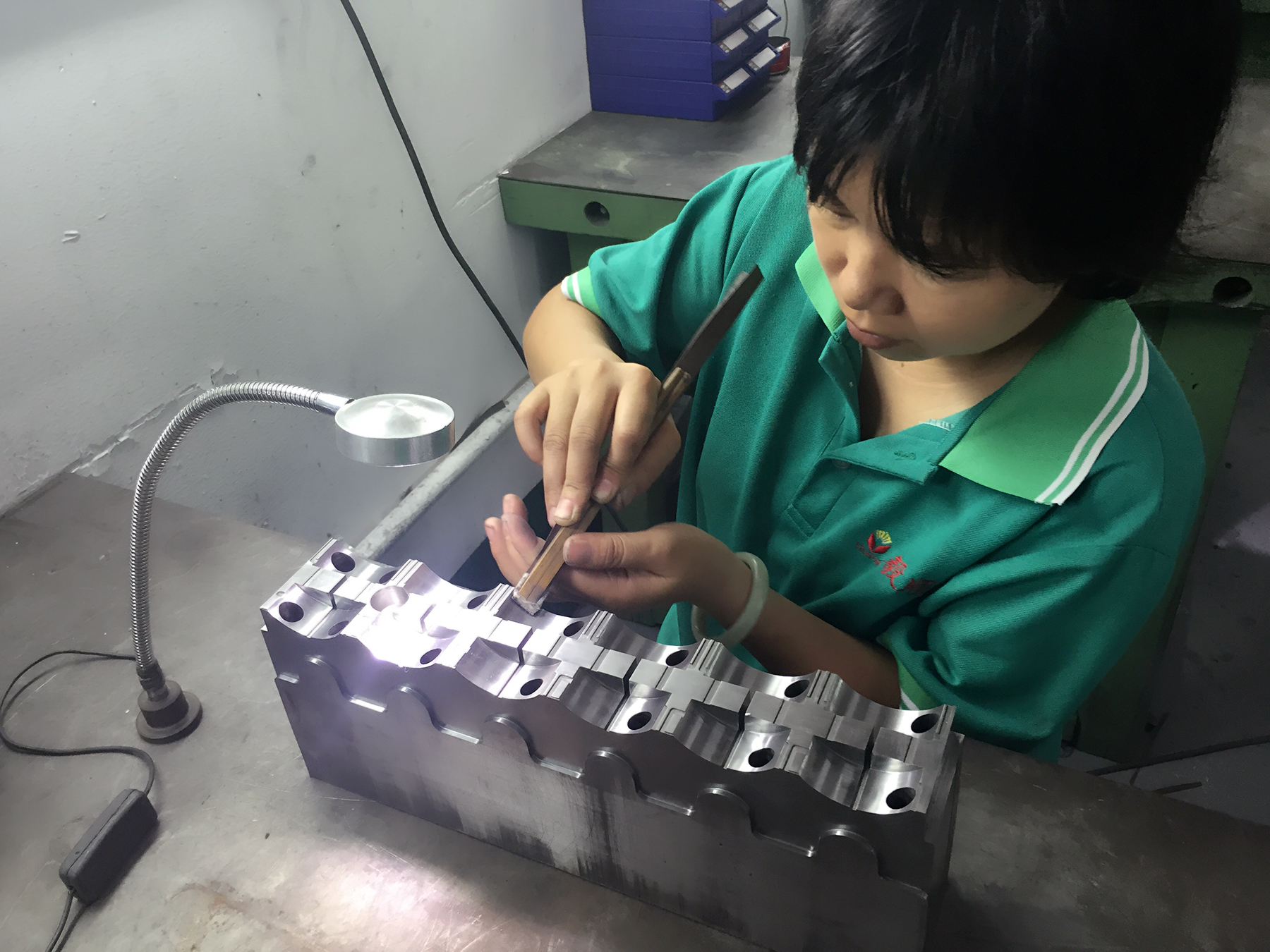 省模師傅正在用砂紙對模具進行省模工序，需確保去除火花紋、打磨平整、光潔度達到一定要求才能進下工序：拋光